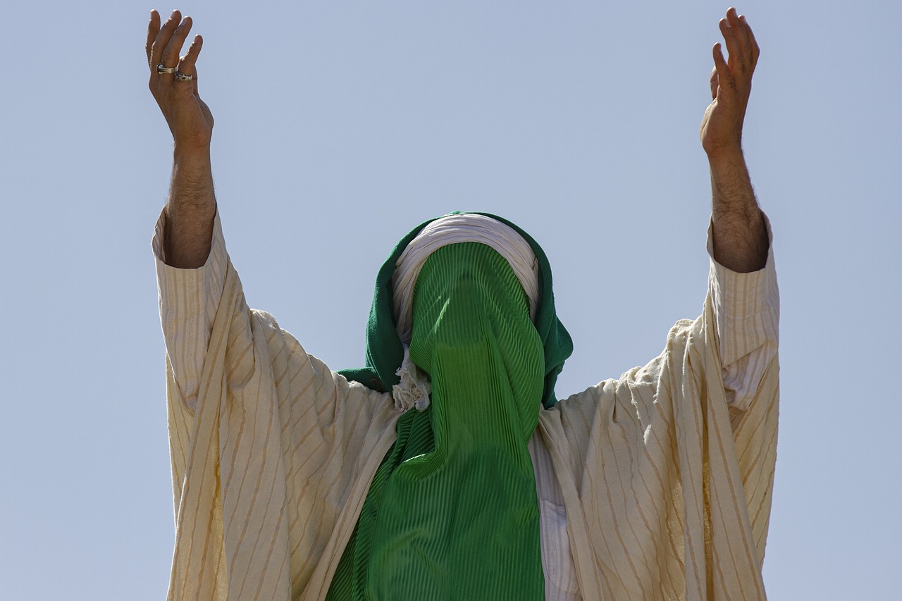 En person med skyddat ansikte lyfter armarna mot himlen, Pixelbay