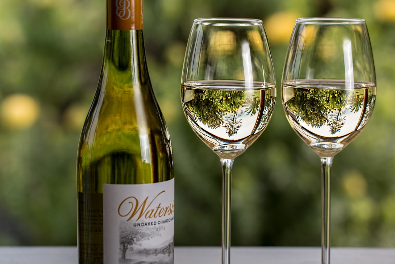 Vinflaska med vitt vin och glas.