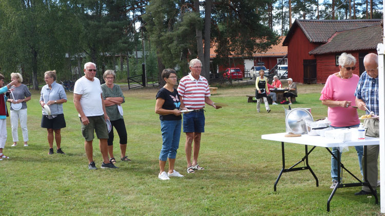 PRO:arna i kön till serveringsbordet höll föredömligt Coronaavstånd när PRO Valbo torsdagen den 27 augusti hade surströmmingsfest, i år utomhus vid Vretas. Foto: Olof Olofsson