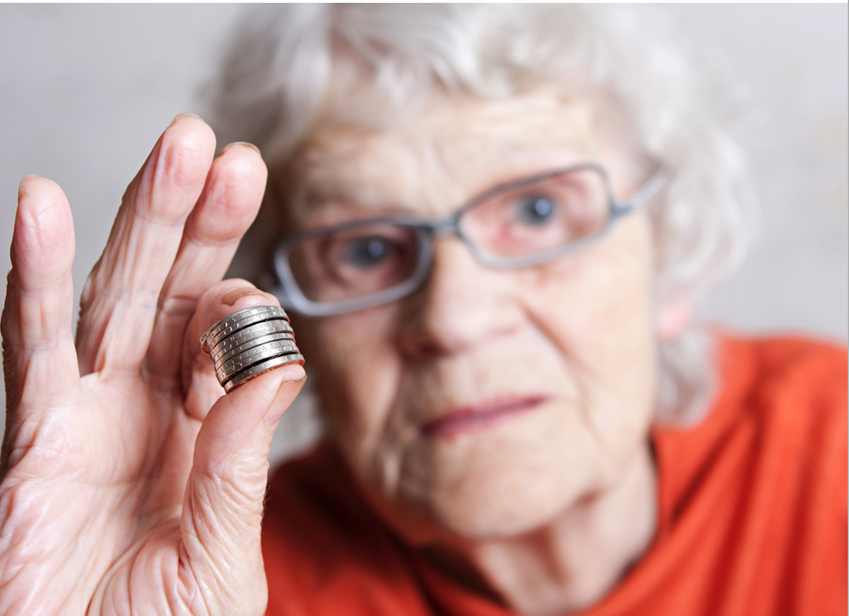 Kvinna håller en stapel med mynt mellan tummen och pekfingret