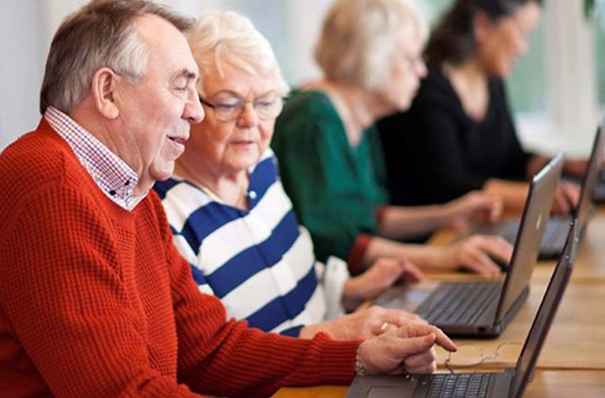 Två pensionärer sitter vid en dator