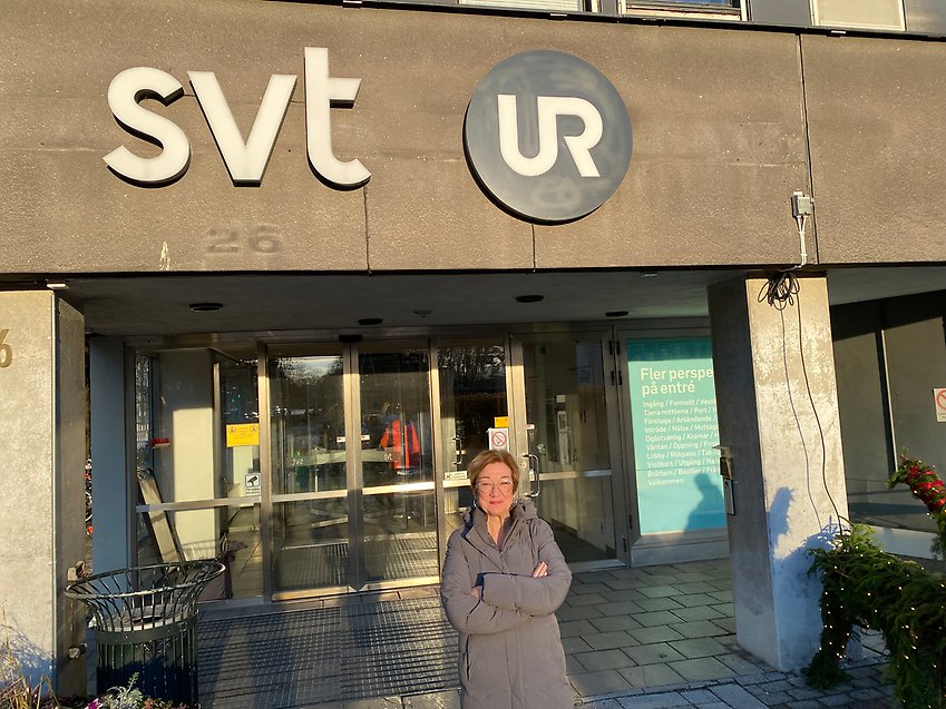 Johanna Hållen som arbetar som PRO:s förbundssekreterare står framför logotyper för SVT och UR