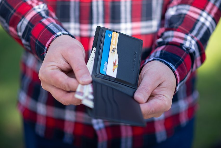 Fotografi på två händer i närbild som håller upp en tom plånbok.