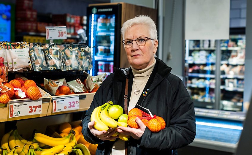 PRO:s ordförande Åsa Lindestam står i en matbutik med frukt i famnen.