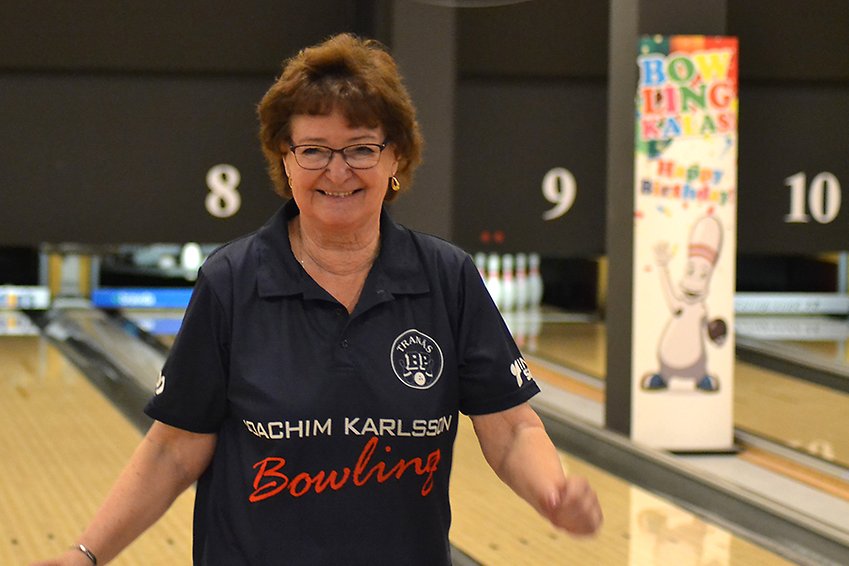 En glad kvinna på en bowlingbana.