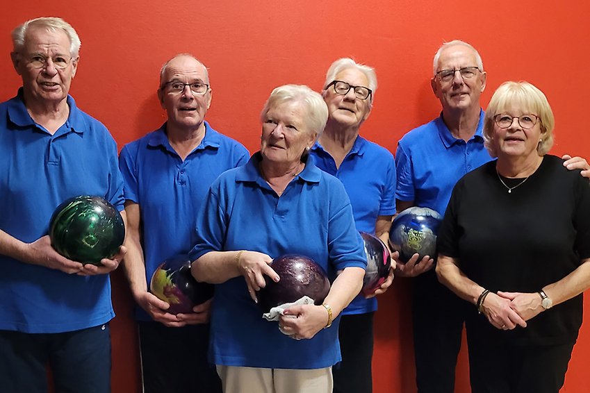 Fem äldre bowlingspelare med klot i händerna.
