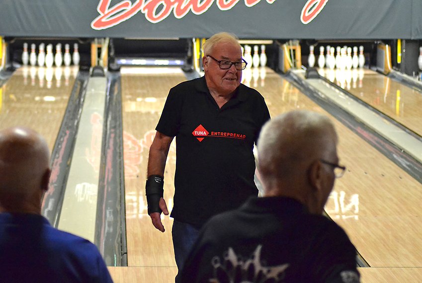 En äldre manlig bowlare med ryggen mot bowlingbanan. Alla käglor är nedslagna.