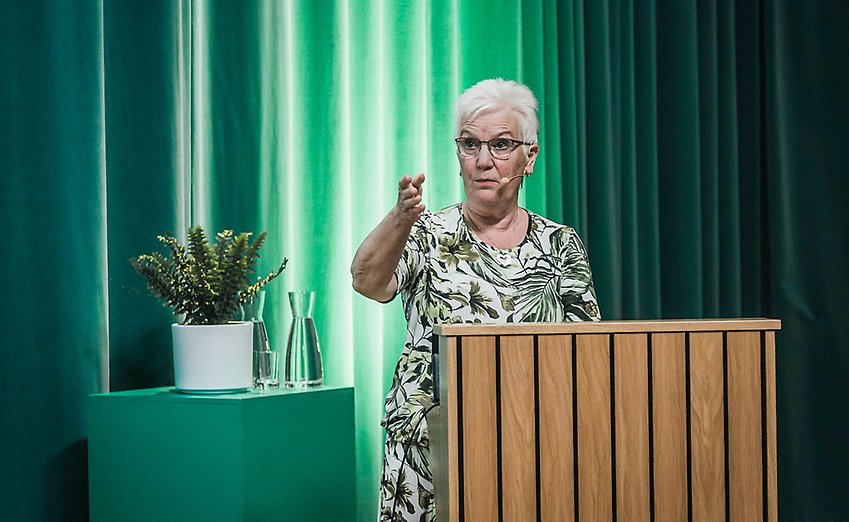 PRO:s ordförande Åsa Lindstam står i en talarstol på en scen
