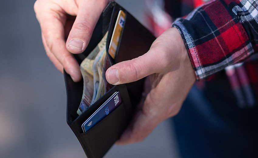 Närbild på en plånbok med sedlar och kontokort.